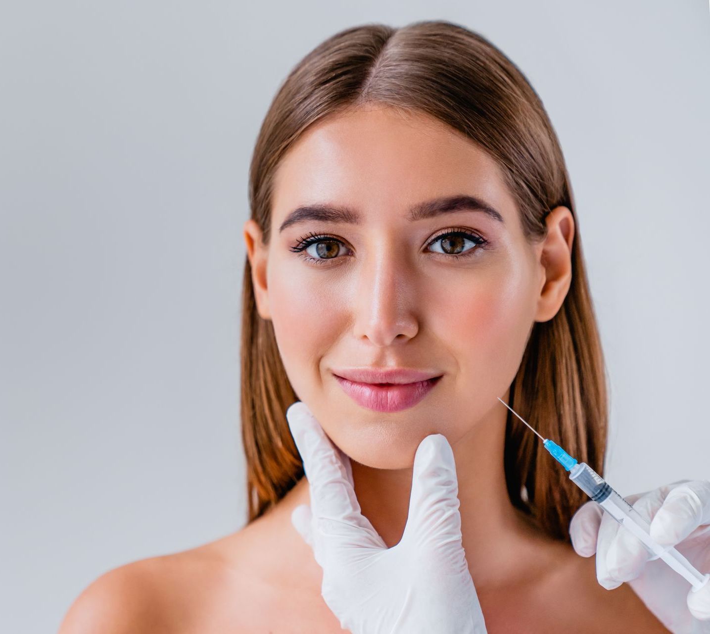 A woman is getting a botox injection in her face.