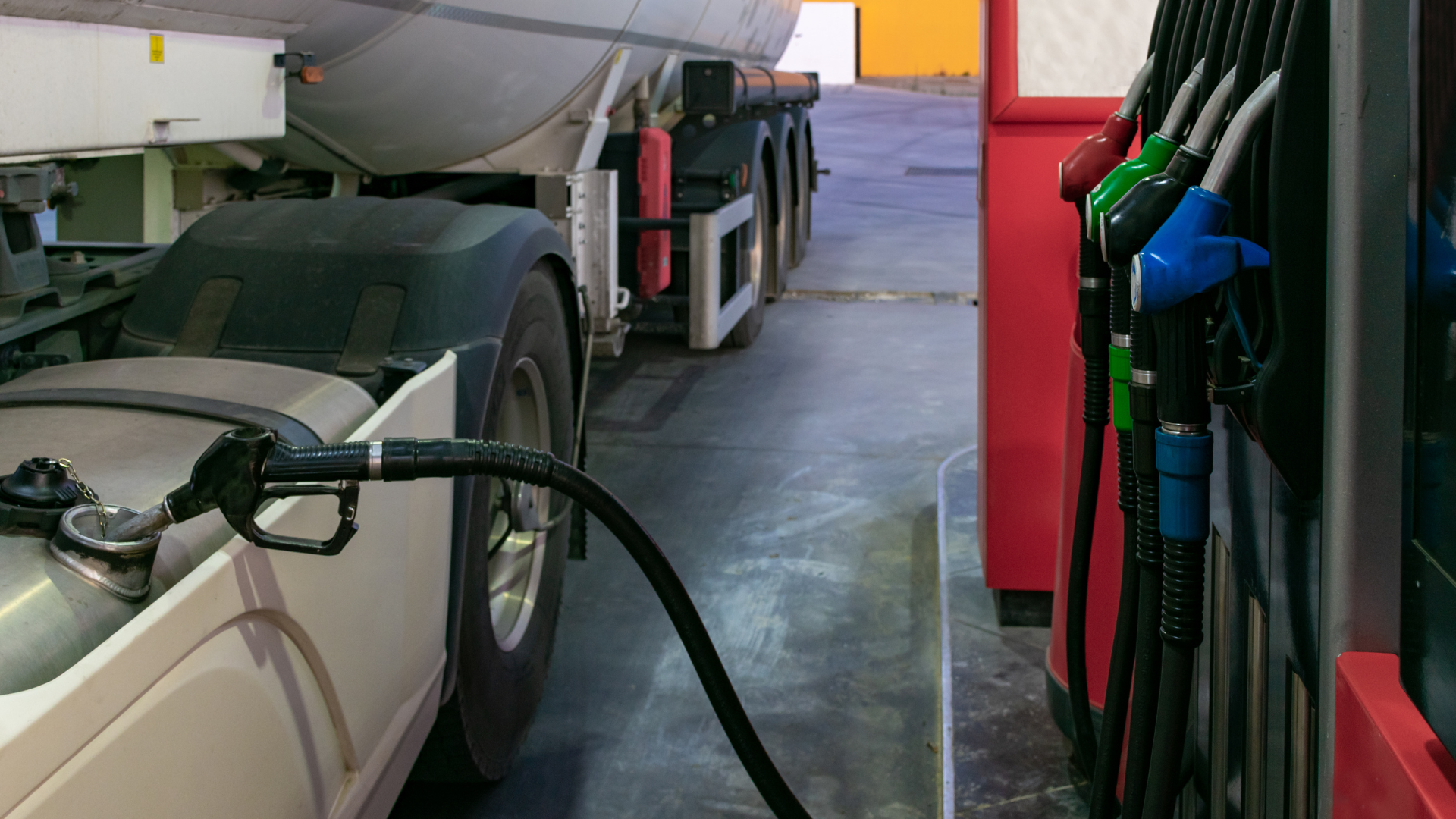 A truck is being filled with gas at a gas station.
