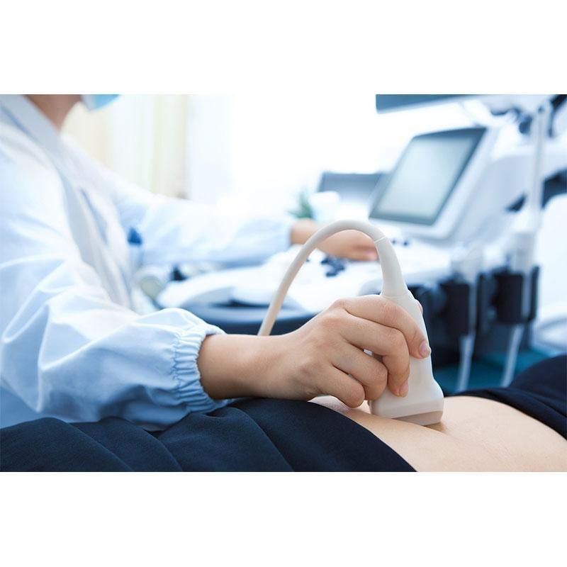 Una donna è seduta su una sedia ginecologica e parla con un medico.