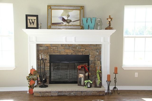 Fireplace with stone surround, white mantel, and decorative items.