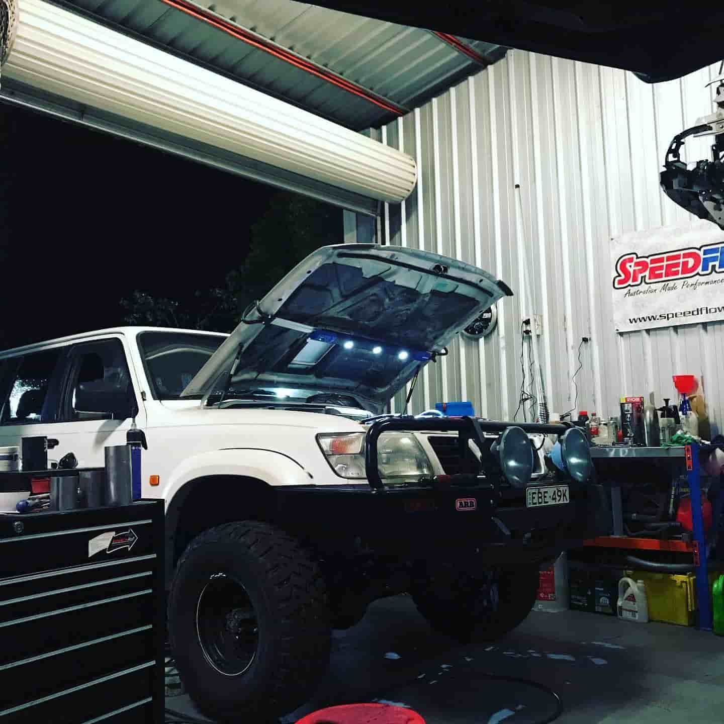 A White Truck Is Parked In A Garage With The Hood Up — ProStreet Automotive & Fabrication In Cardiff, NSW