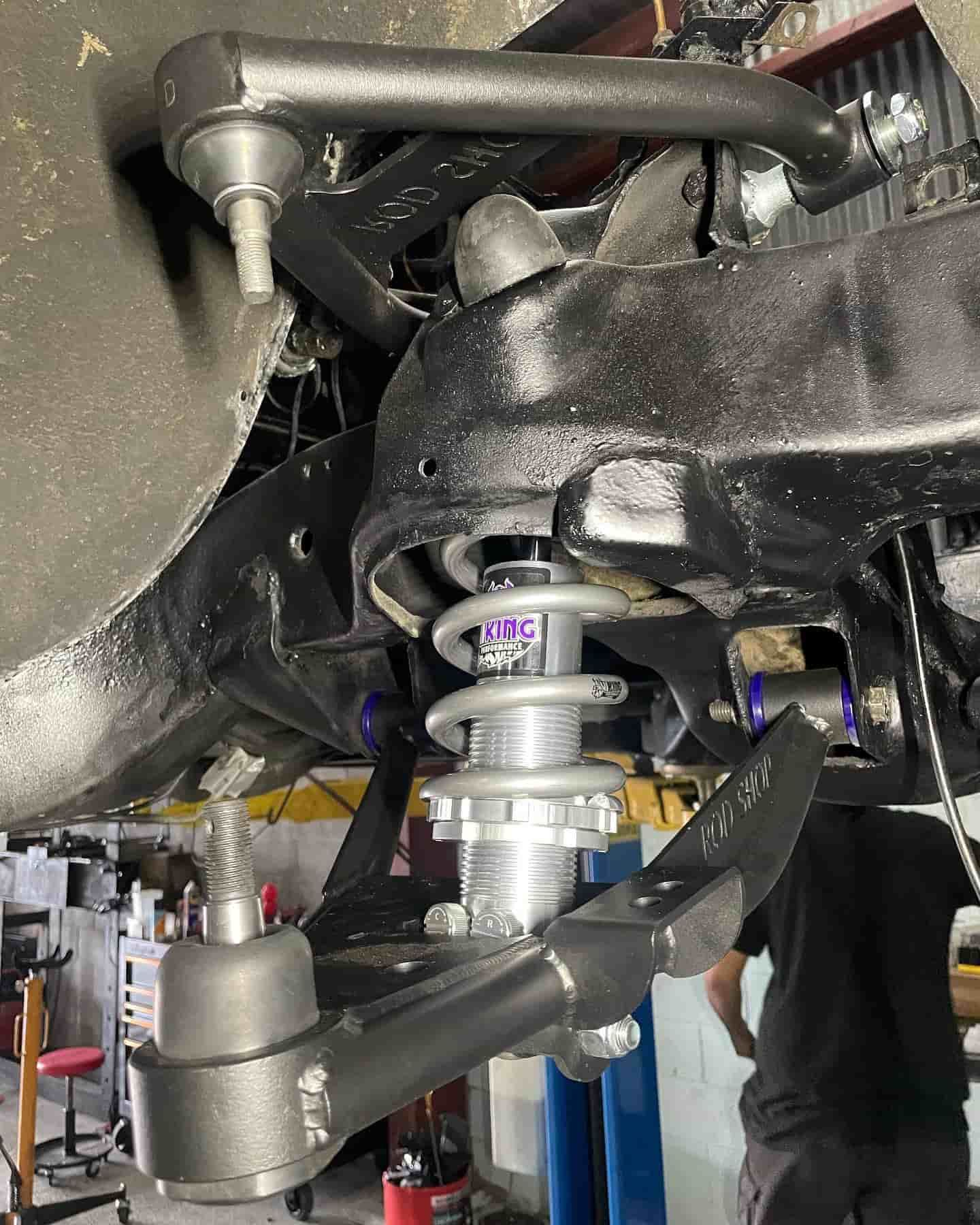 A Man Is Working On The Underside Of A Car In A Garage — ProStreet Automotive & Fabrication In Cardiff, NSW