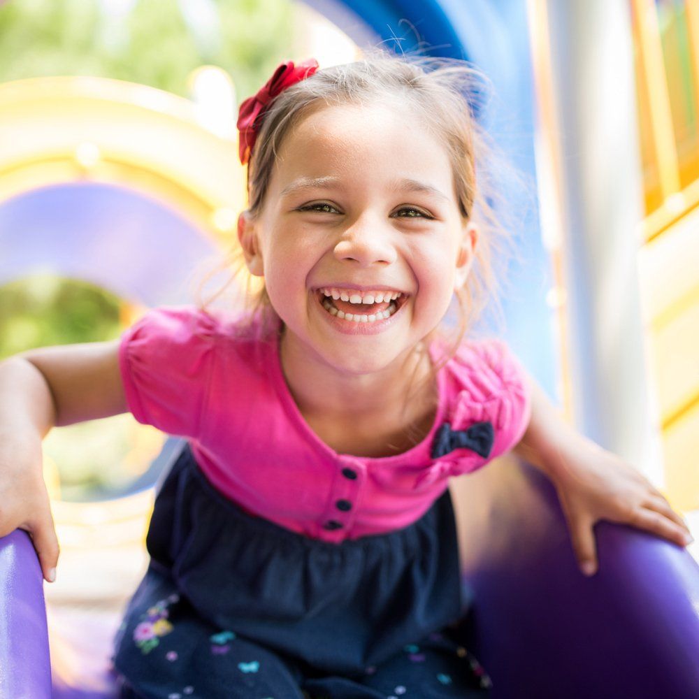 Girl Smiling on Slide — West Des Moines, IA — A Child's World