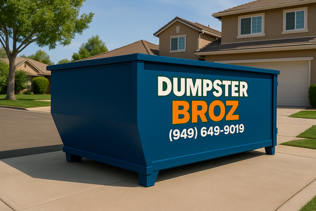 A black dumpster is sitting on top of a white surface.