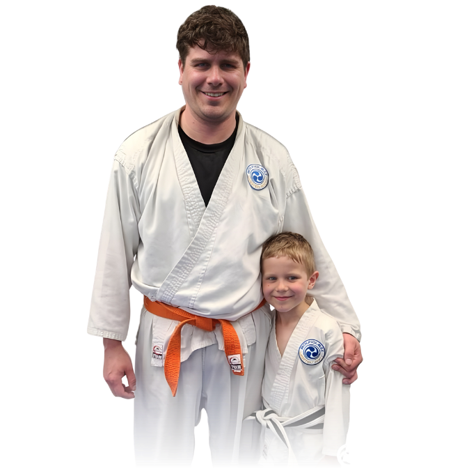 Man pointing, smiling, wearing black hoodie; arm tattoo visible.