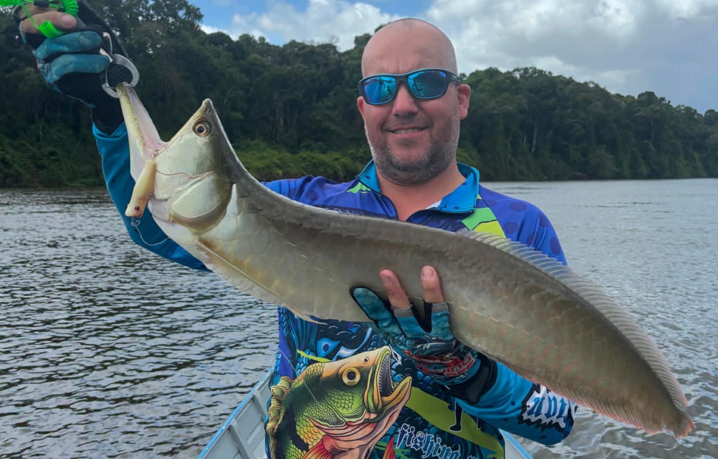 Jungle specialist guide holding large Amazon River fish during expedition
