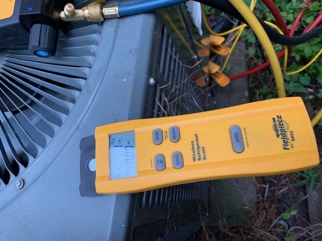 A yellow fluke device is sitting next to an air conditioner