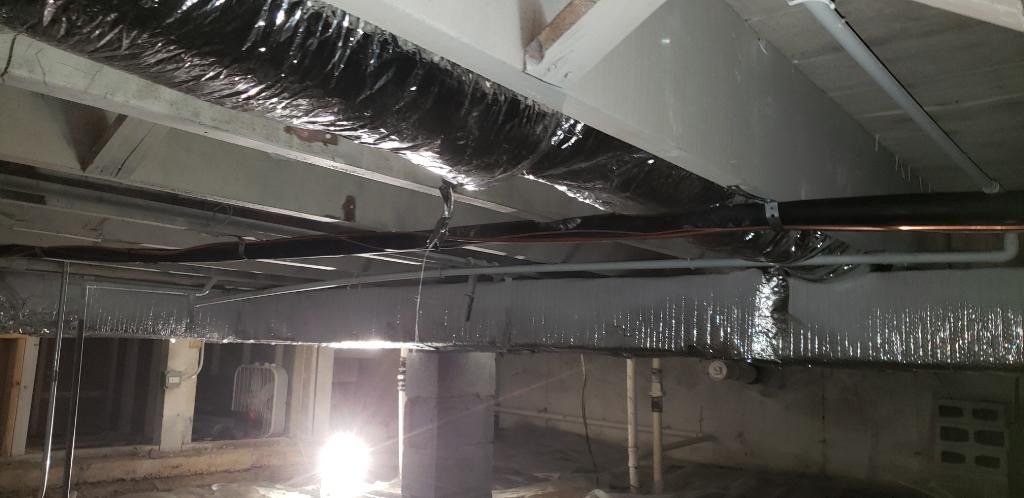 A ceiling with a lot of pipes coming out of it.