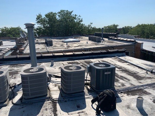 A roof with a lot of air conditioners on it