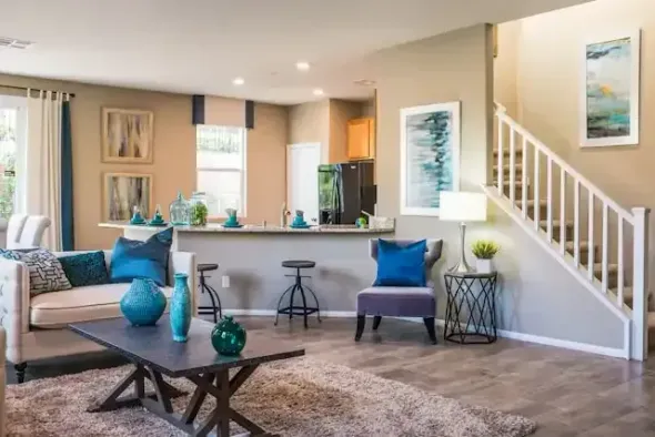 A living room with a couch , chairs , coffee table and stairs.