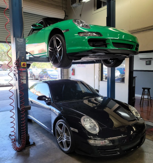 A black vehicle and a green vehicle at our repair shop | Foreign Sports