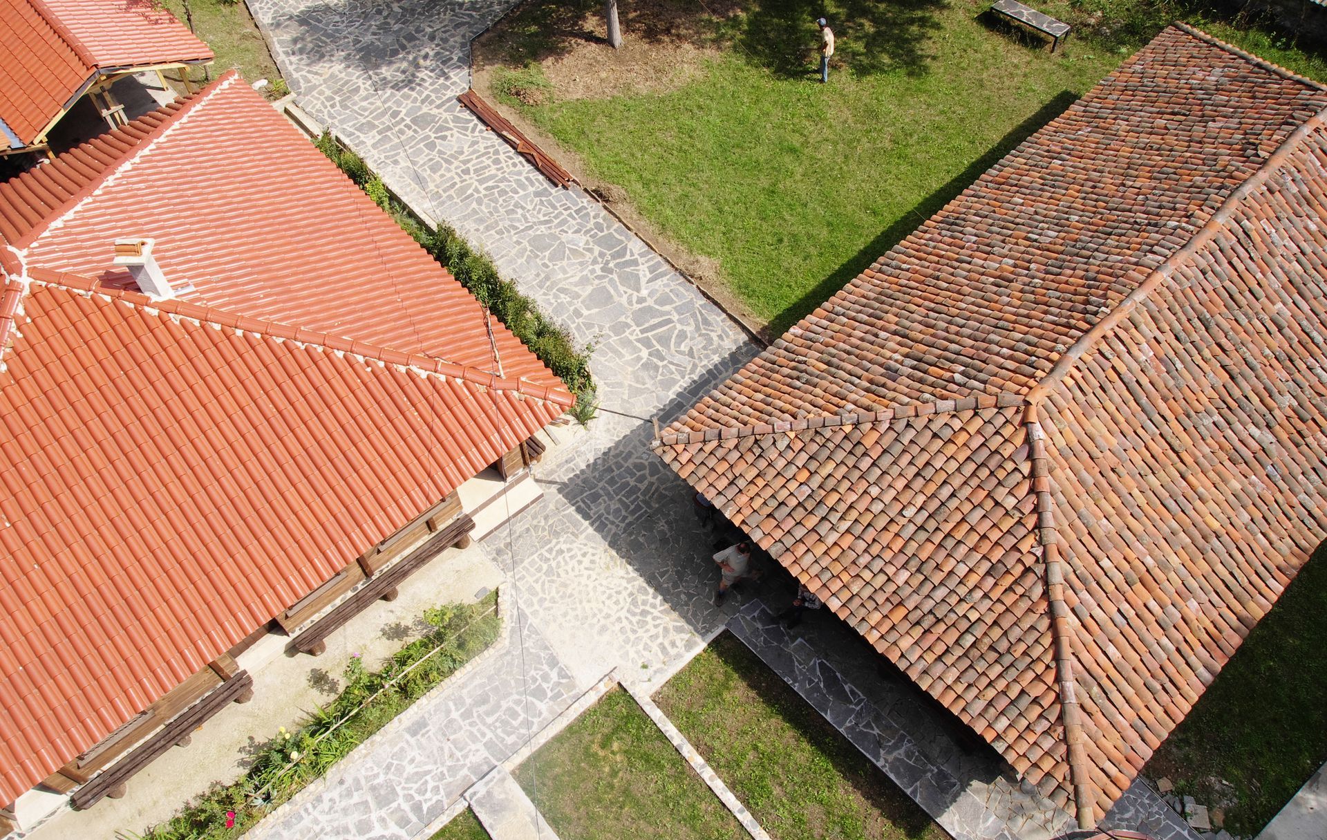 Applying black asphalt sealant with a squeegee on a paved surface.