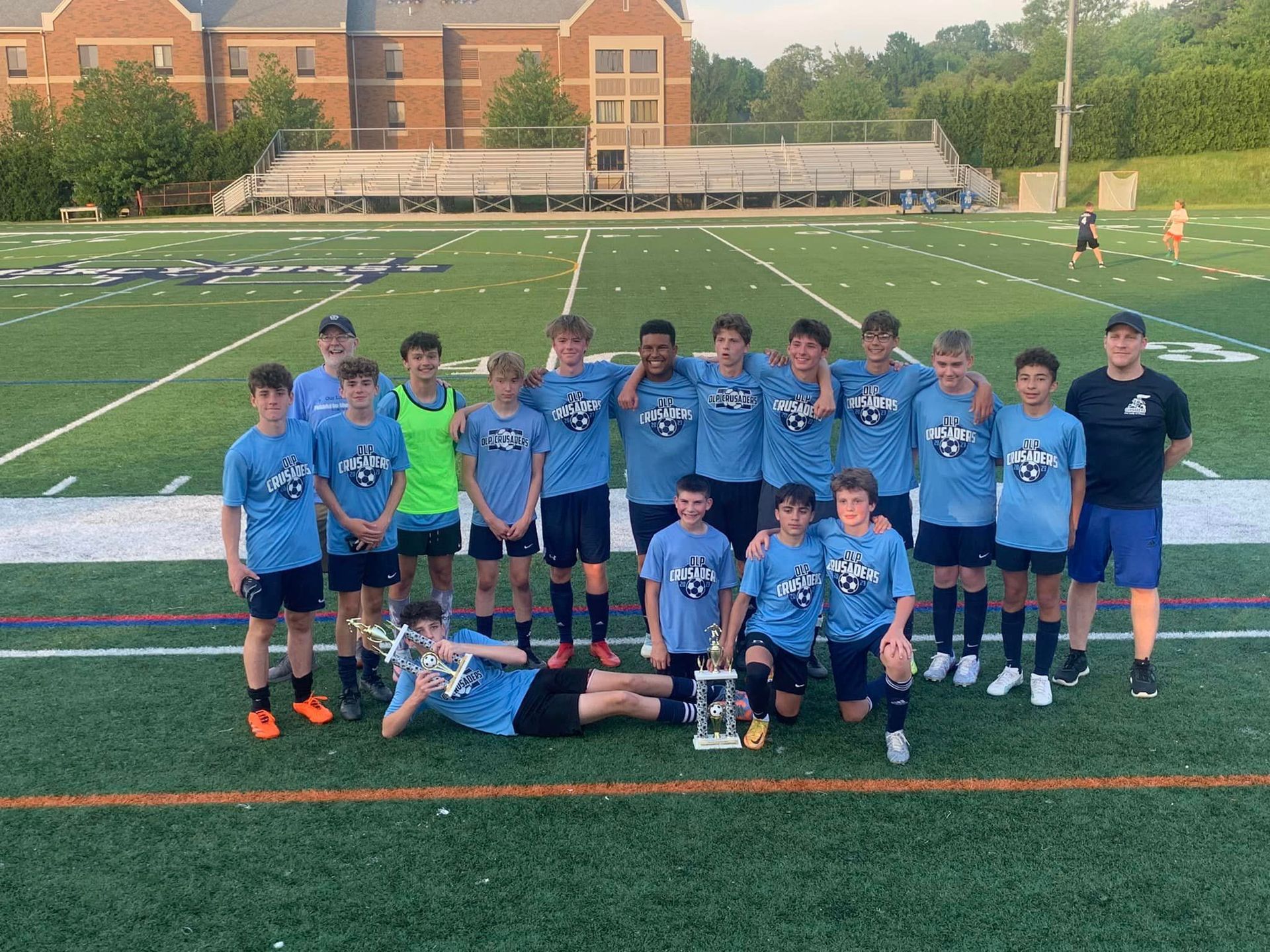 A soccer team poses for a picture on a field