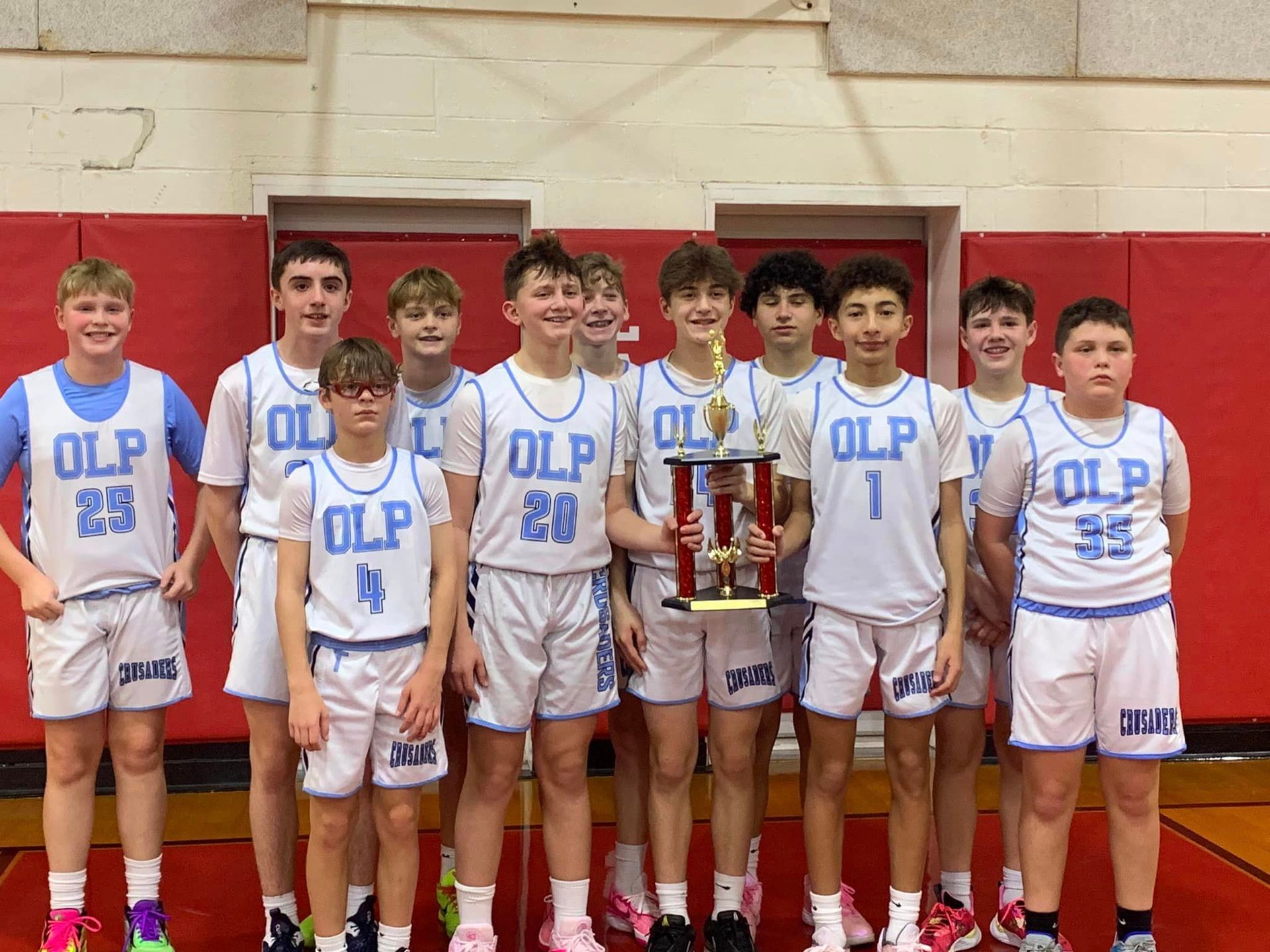 A group of boys wearing olp jerseys pose for a picture