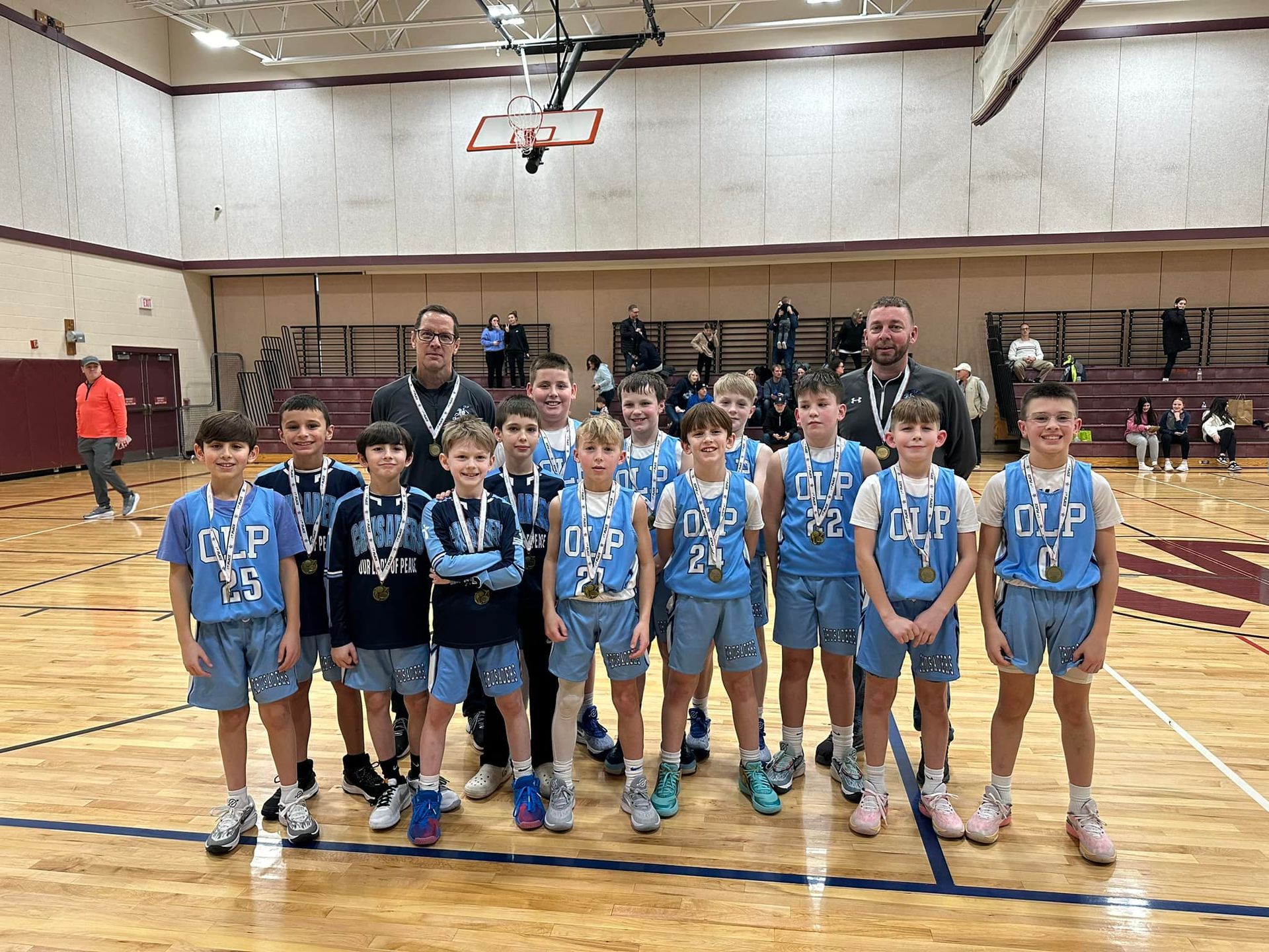 A group of young boys are posing for a picture on a basketball court