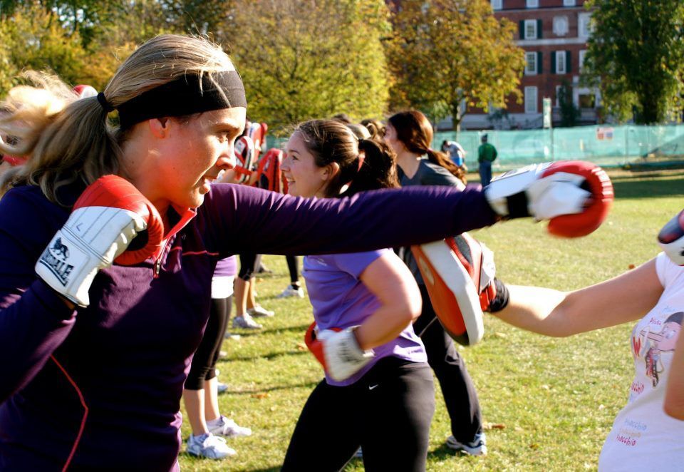 A woman wearing a headband and boxing gloves with the word tiger on them