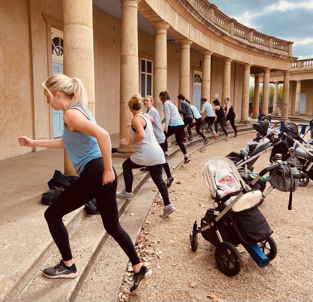 A group of people are doing exercises in front of a building.