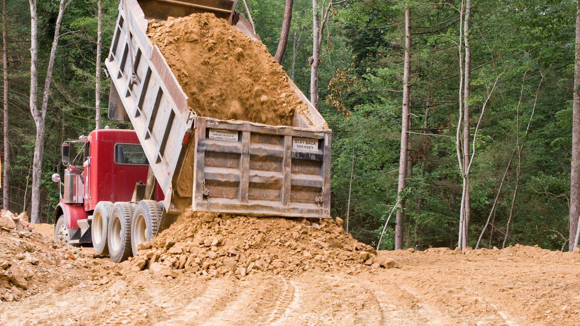 A dump trailer is parked on the side of the road.