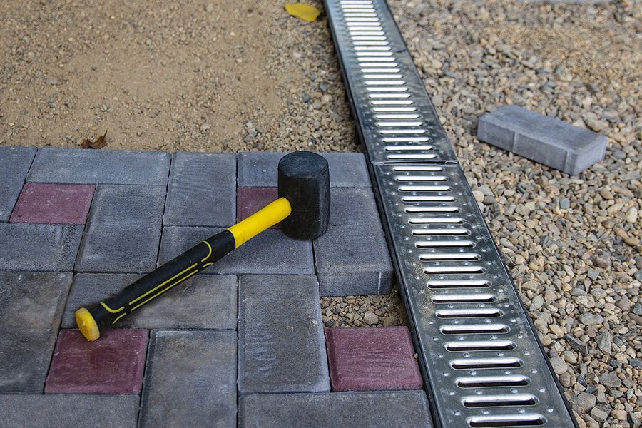 under installation of brick walkway beside the drainage