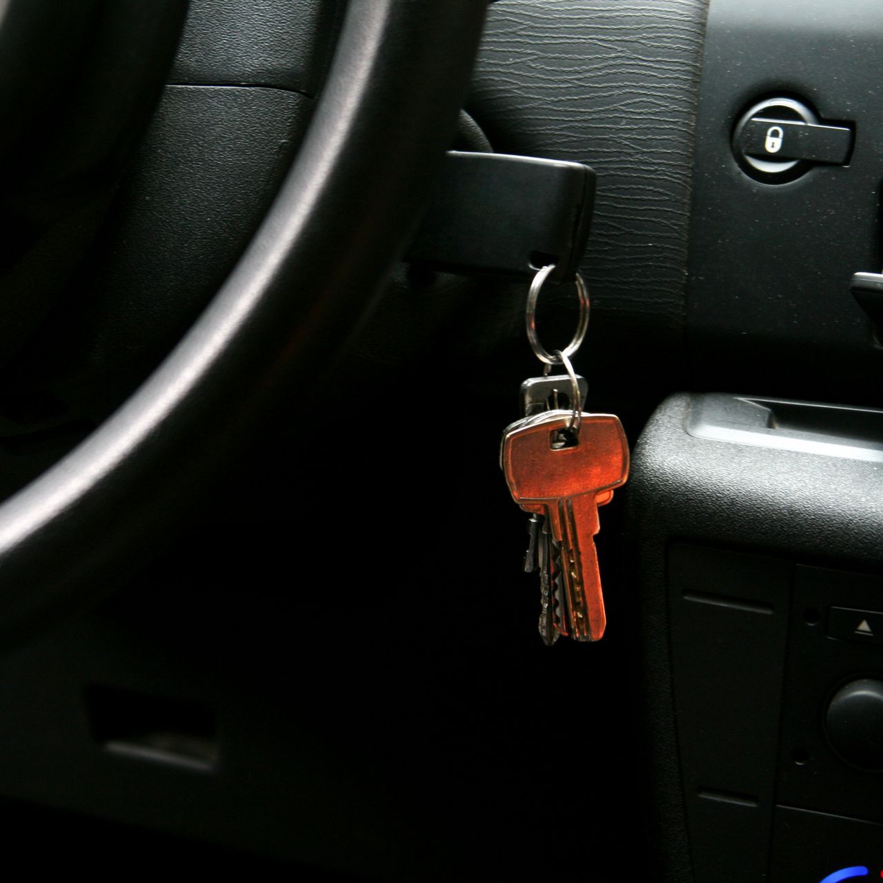 A car key is hanging from the steering wheel