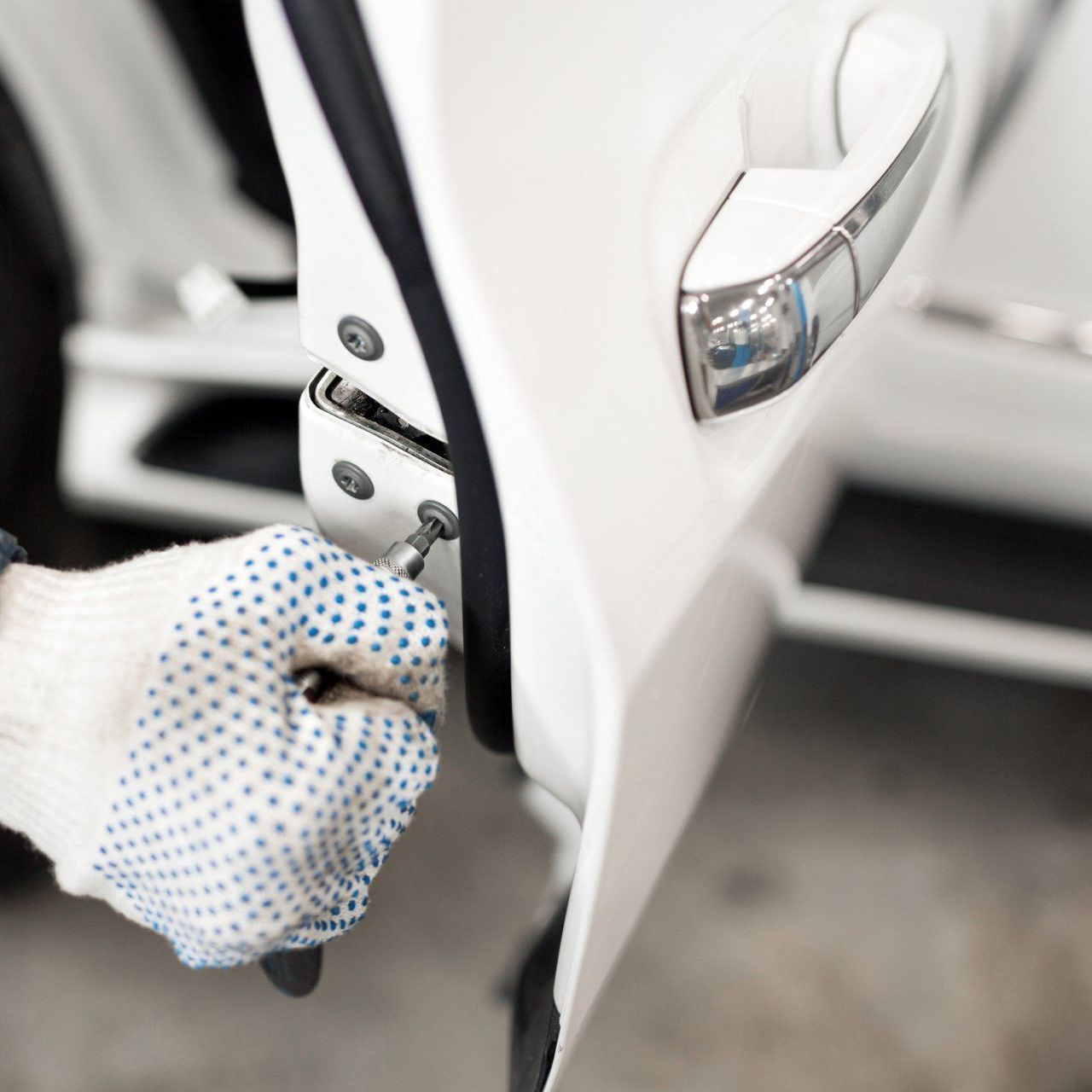 A person wearing gloves is opening a car door