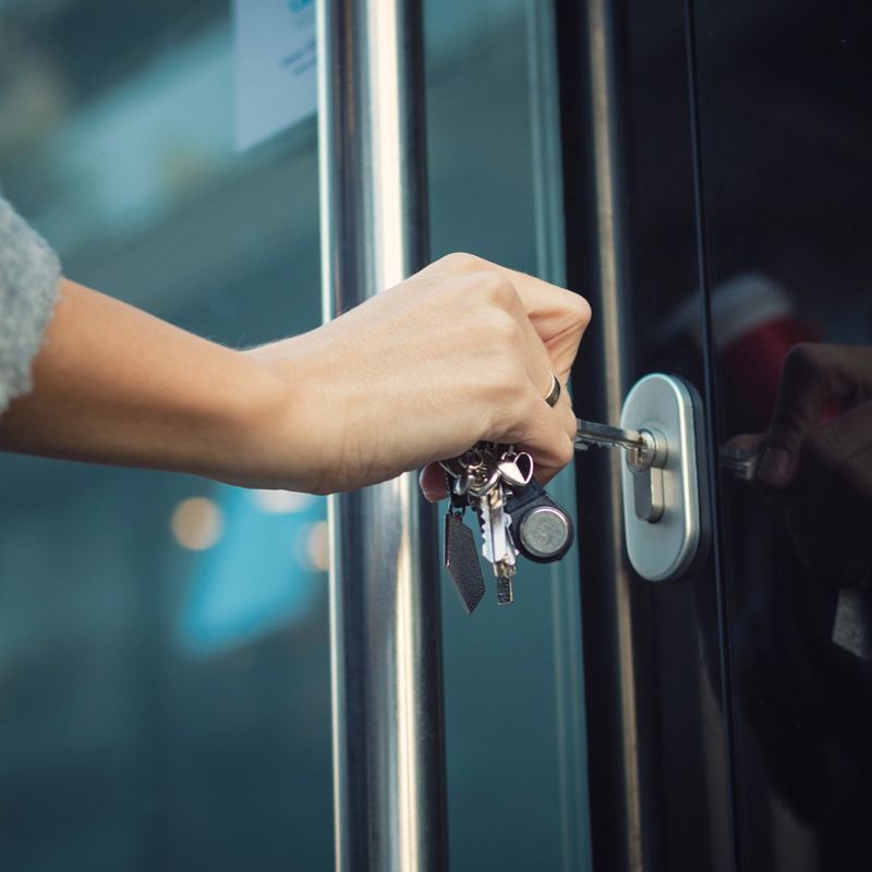 A person is opening a door with a key.