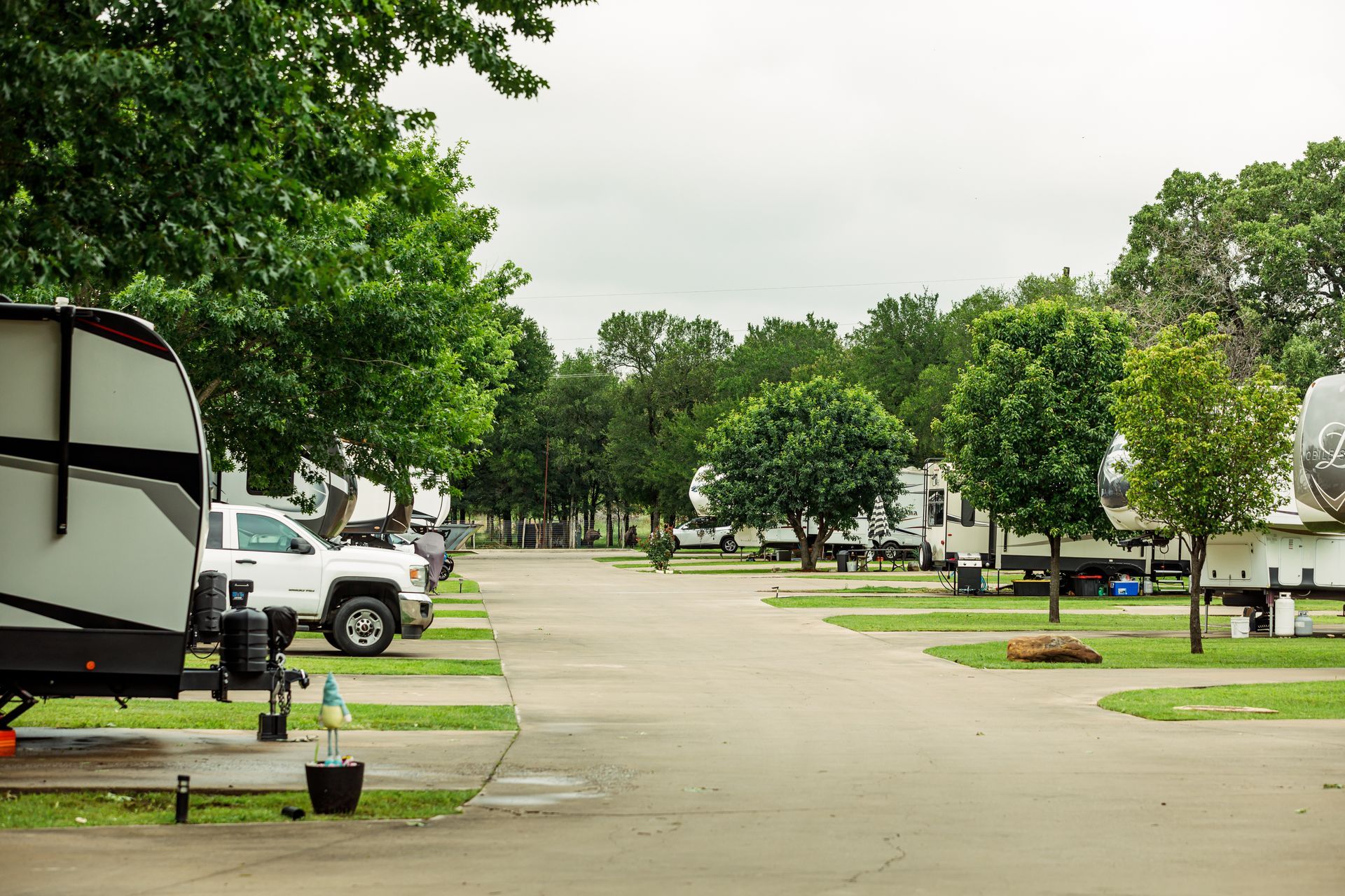 A row of rvs are parked in a campground.