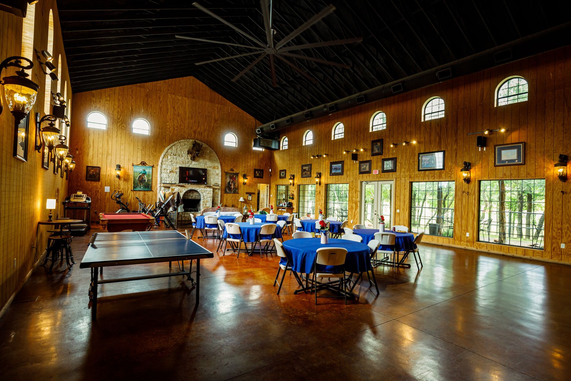 A large room with tables and chairs and a ping pong table.