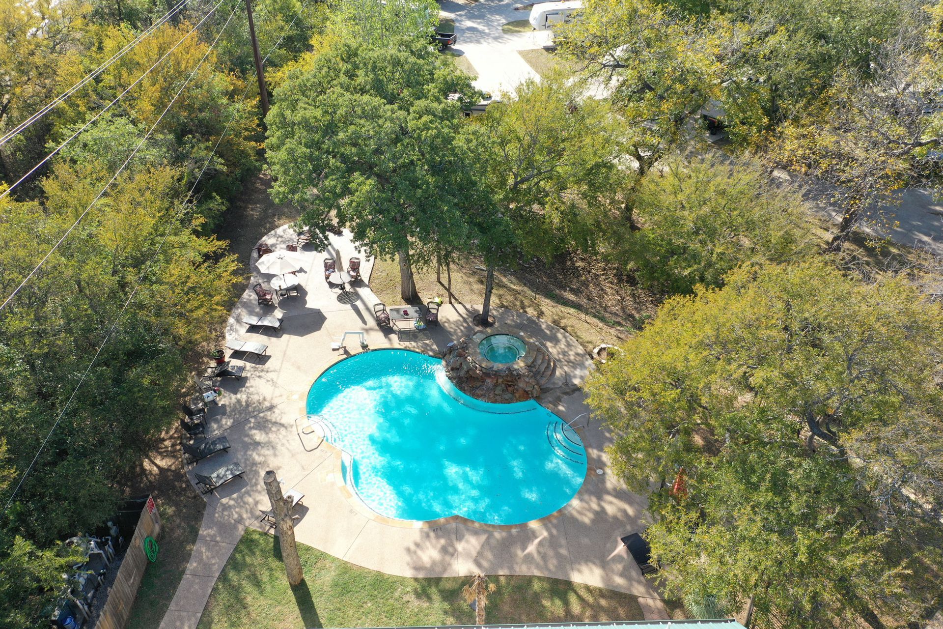 An aerial view of a swimming pool surrounded by trees
