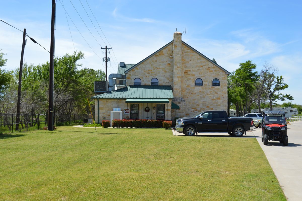 A black truck is parked in front of a stone building