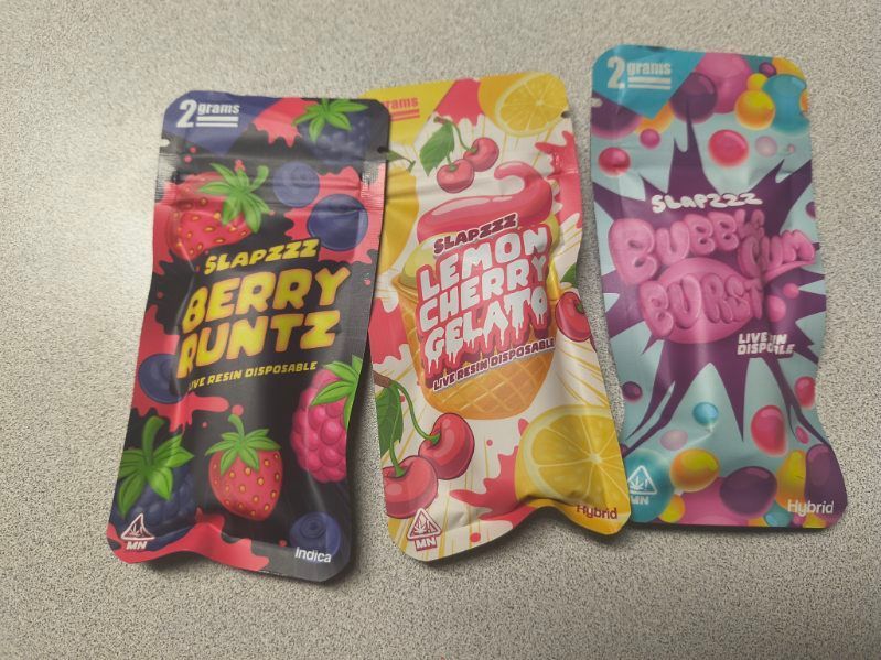 Sweet potato fries with dipping sauce in a metal basket, garnished with parsley.