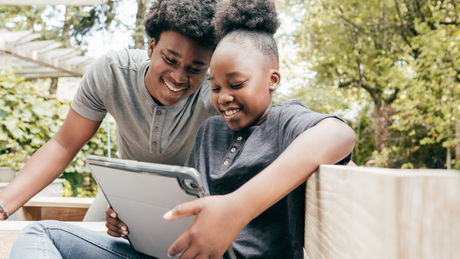 Un garçon et une fille regardent une tablette ensemble.