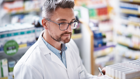 Un pharmacien regarde une ordonnance dans une pharmacie.