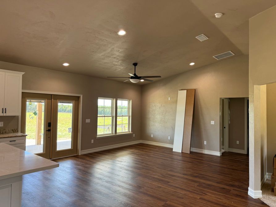 Interior view of a new home with wooden floors, high ceilings, and large windows.