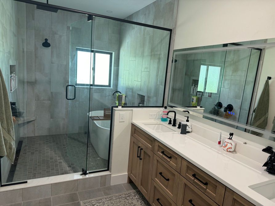 Modern bathroom with glass shower, vanity, and neutral tile.