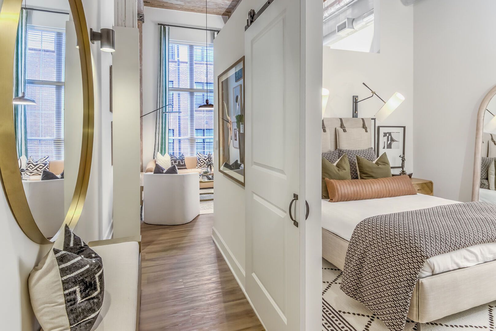 Bedroom in a modern apartment with a neatly made bed and a connected living area.
