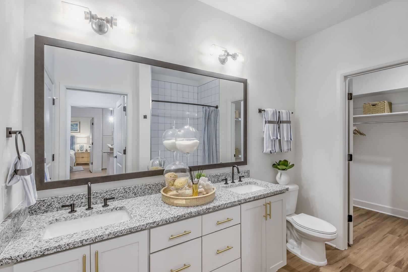 Double-sink bathroom vanity with granite countertop and large framed mirror.