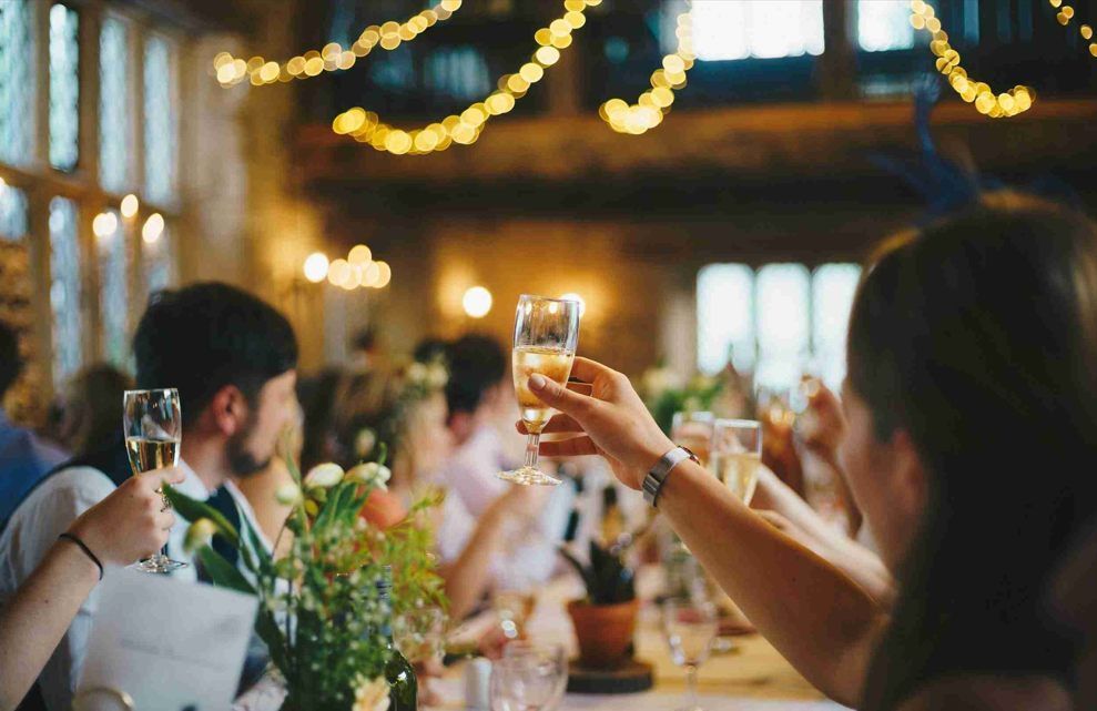 A group of people are toasting with champagne glasses at a wedding reception.