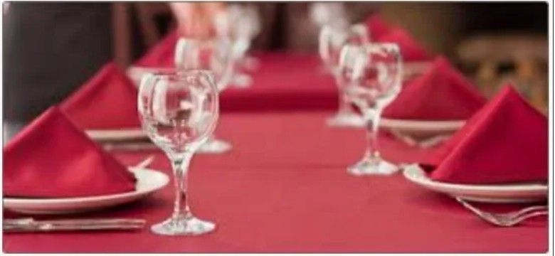 A table with red napkins and wine glasses on it