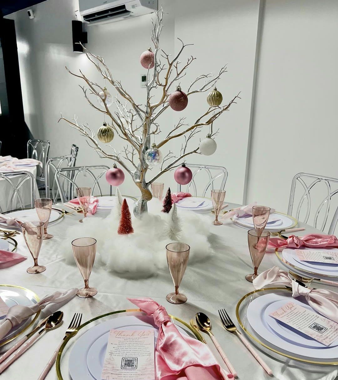 A table with plates , glasses , and a christmas tree on it