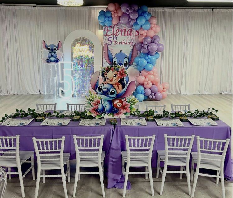 A table and chairs are set up for a birthday party with a lilo and stitch theme.