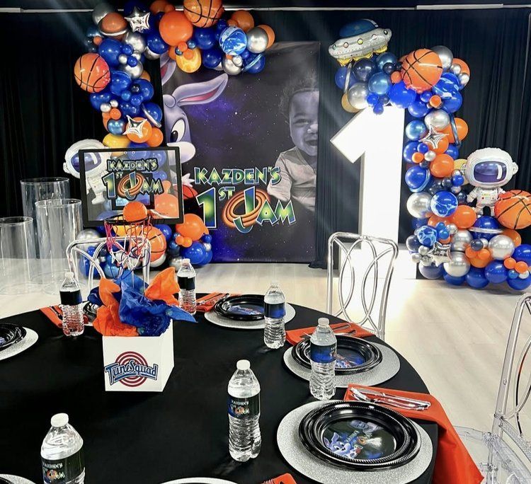 A table set for a birthday party with balloons and plates.
