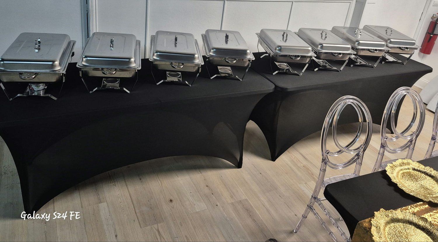 A row of buffet trays are lined up on a table.