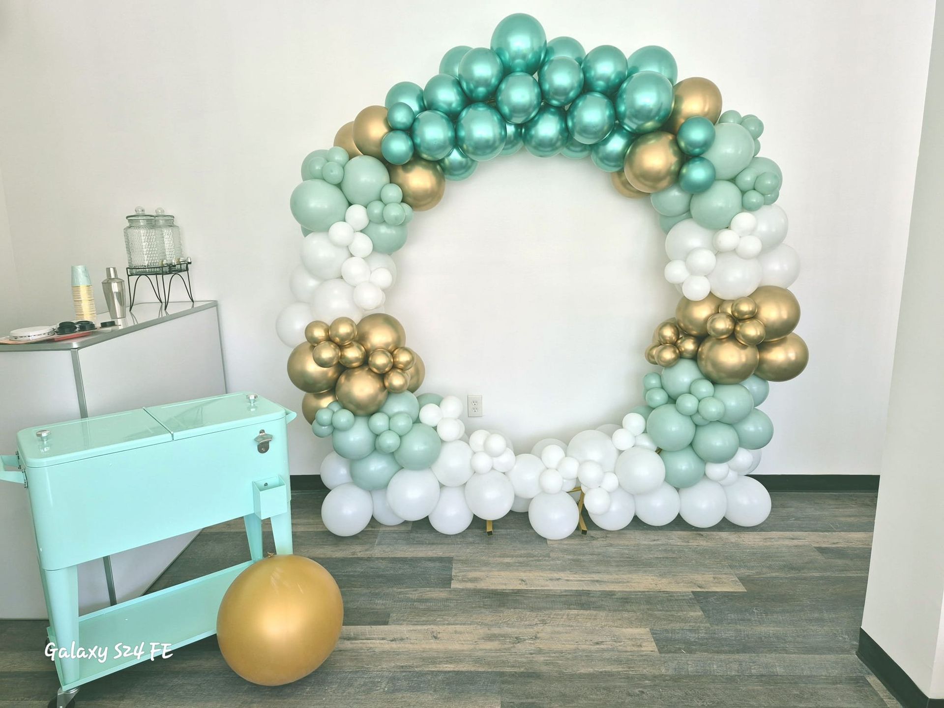 A room filled with balloons and a cooler.