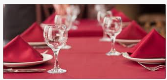 A table with red napkins and wine glasses on it