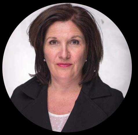 Une femme aux cheveux bruns sourit largement, vêtue d'une chemise rayée, sur un fond blanc.