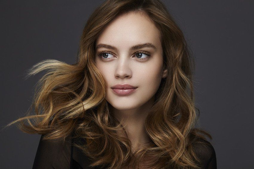 close up view of a young beautiful woman with long brown wavy hair