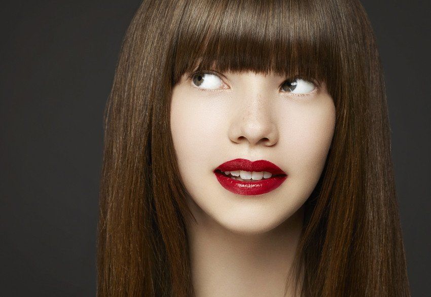 studio portrait of woman with bangs and red lips