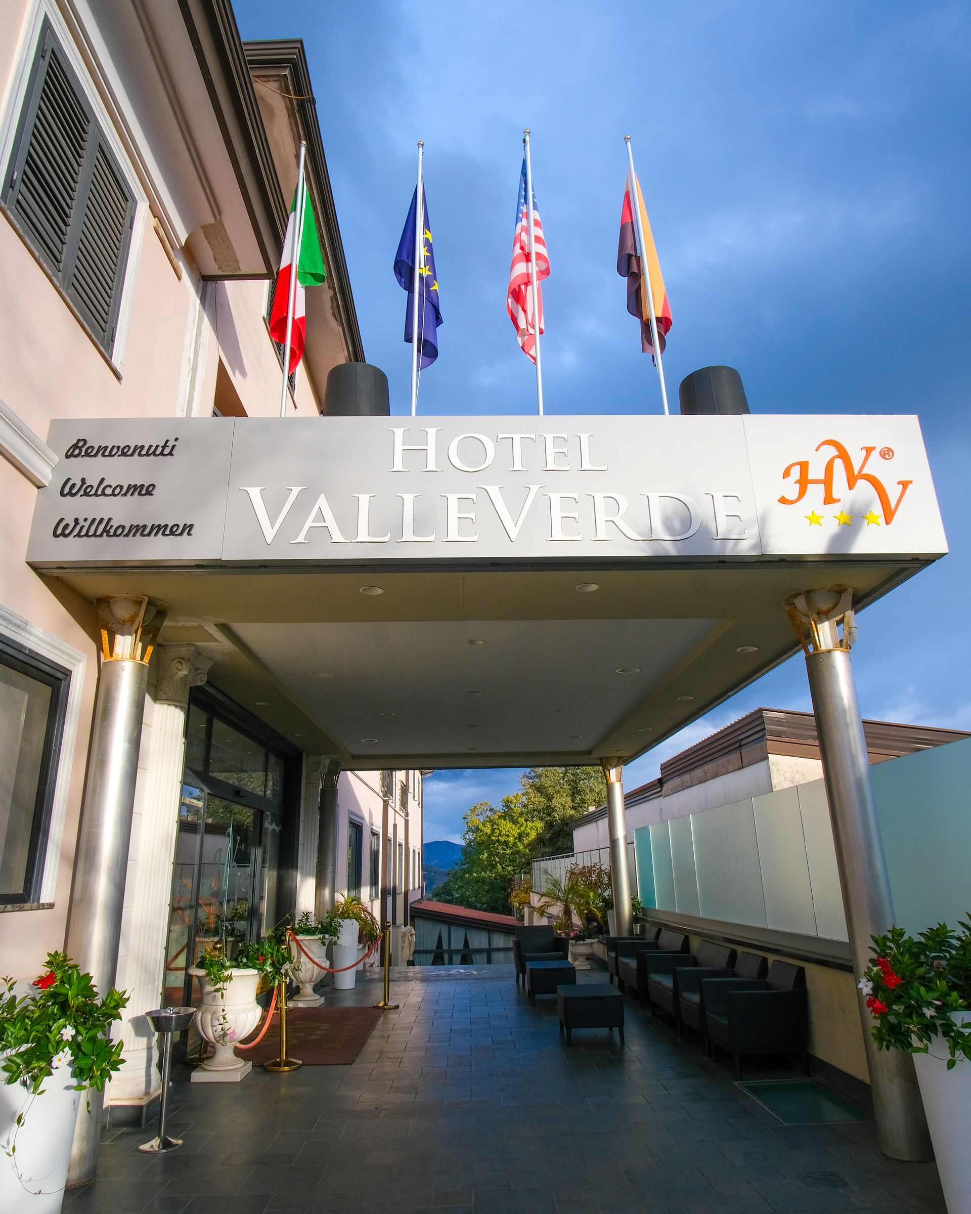 Ingresso dell'Hotel Valleverde con bandiere, tenda e testo.
