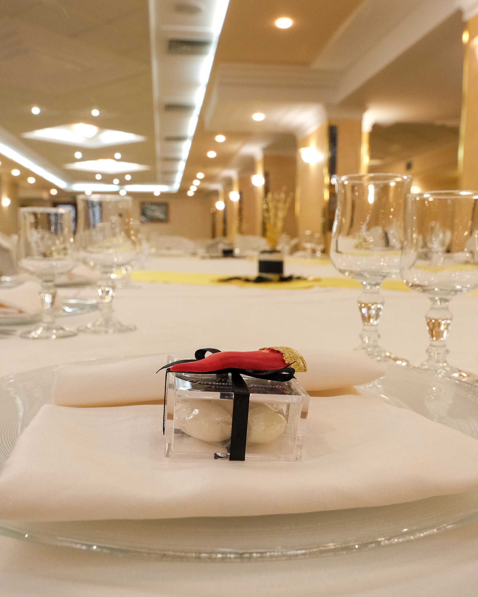 Tavolo da pranzo formale apparecchiato per un evento speciale, con apparecchiatura, centrotavola e illuminazione dall'alto.